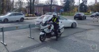 Policjant na motocyklu pilnuje porządku w rejonie cmentarza